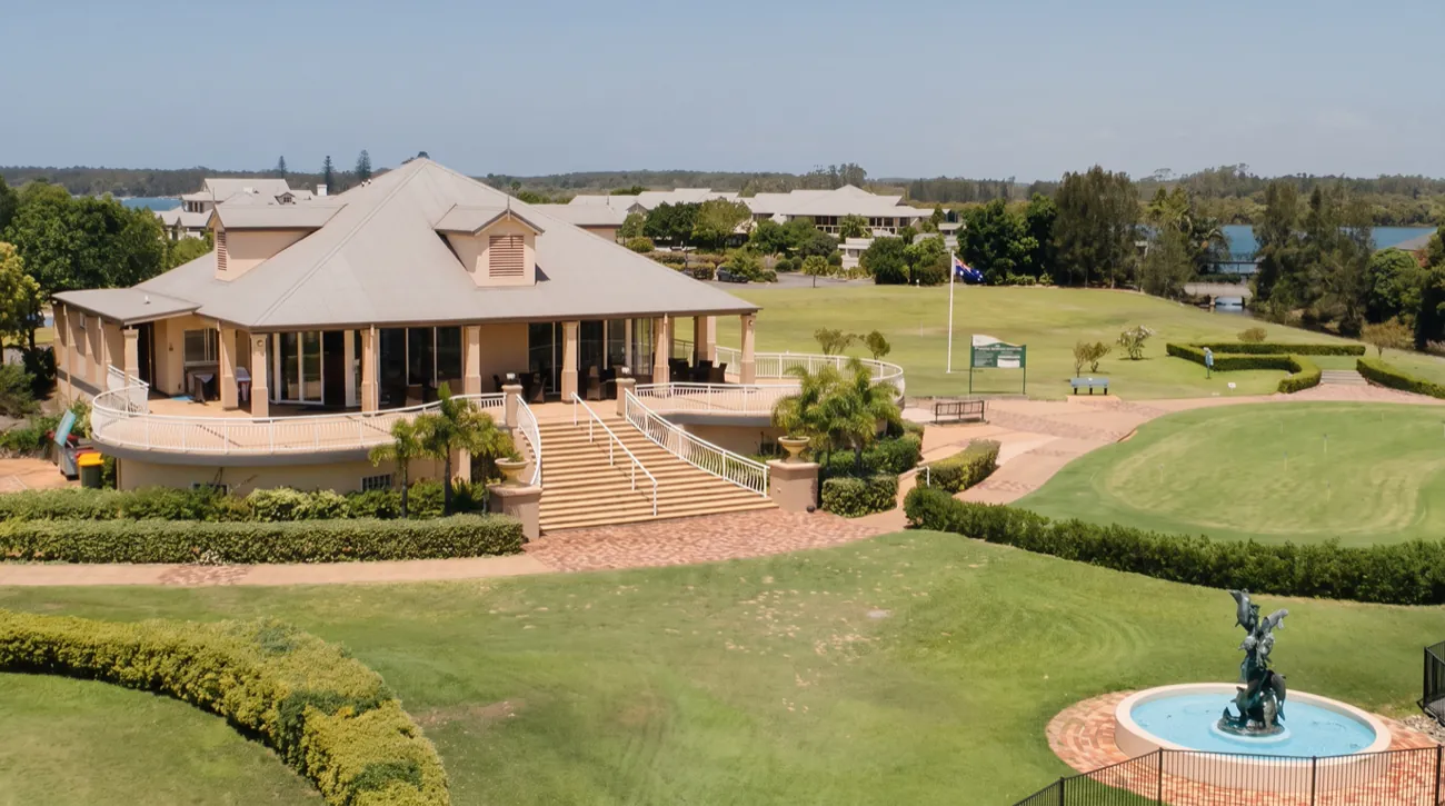 An aerial view of the Harrington Waters clubhouse, the putting green, the fountain garden and the Manning River beyond