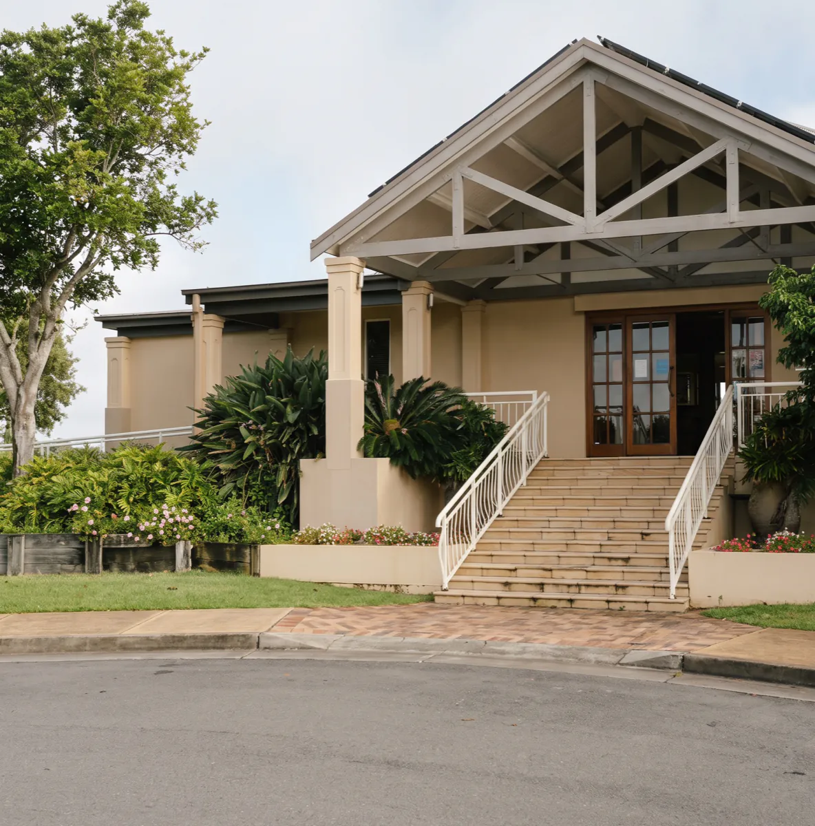 The front entrance of the Harrington Waters clubhouse, with its gabled portico, timber trusses and the wide steps up to the doors