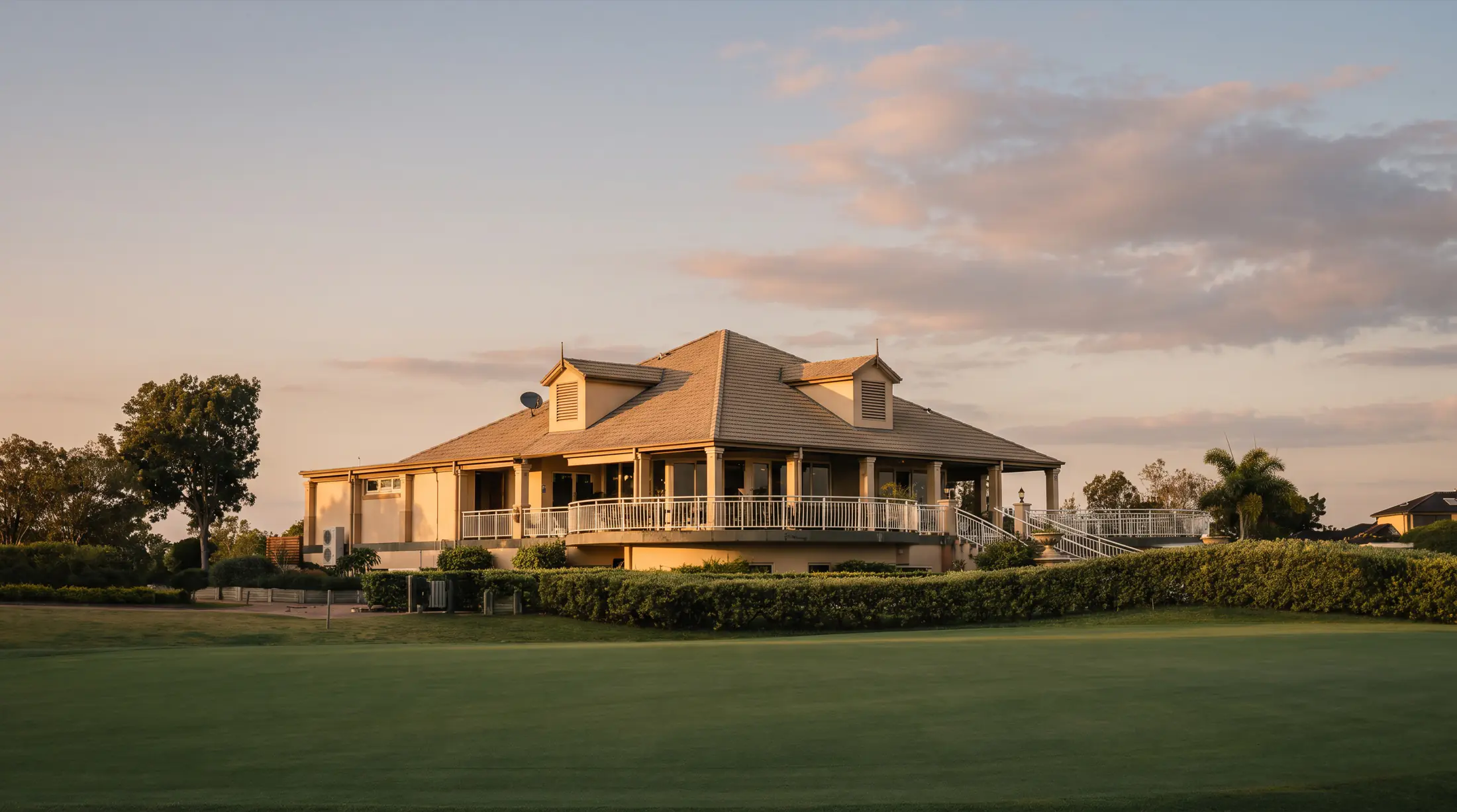 The Harrington Waters clubhouse at golden hour, seen across the green